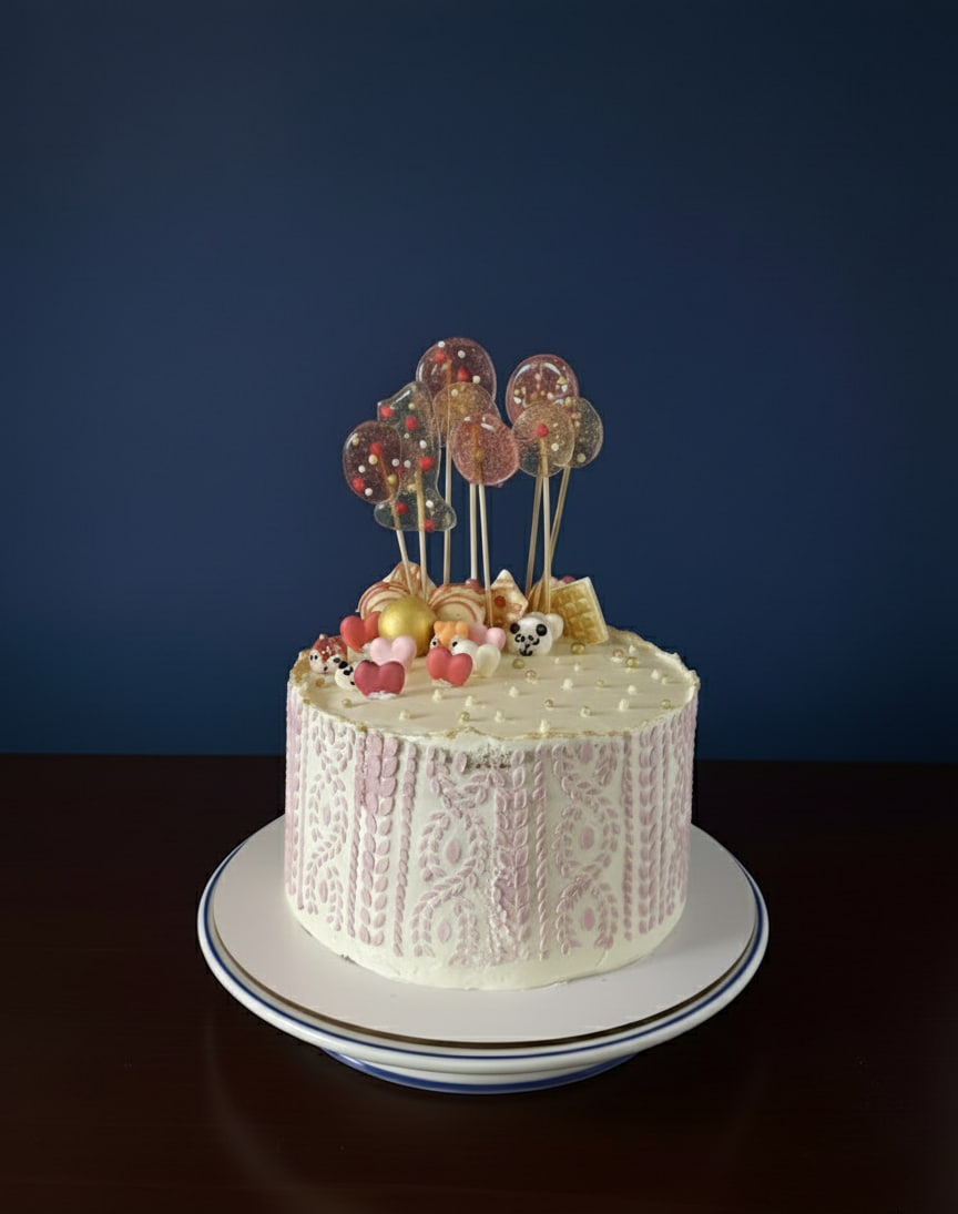 Festive white cake decorated with colorful lollipops and hearts.